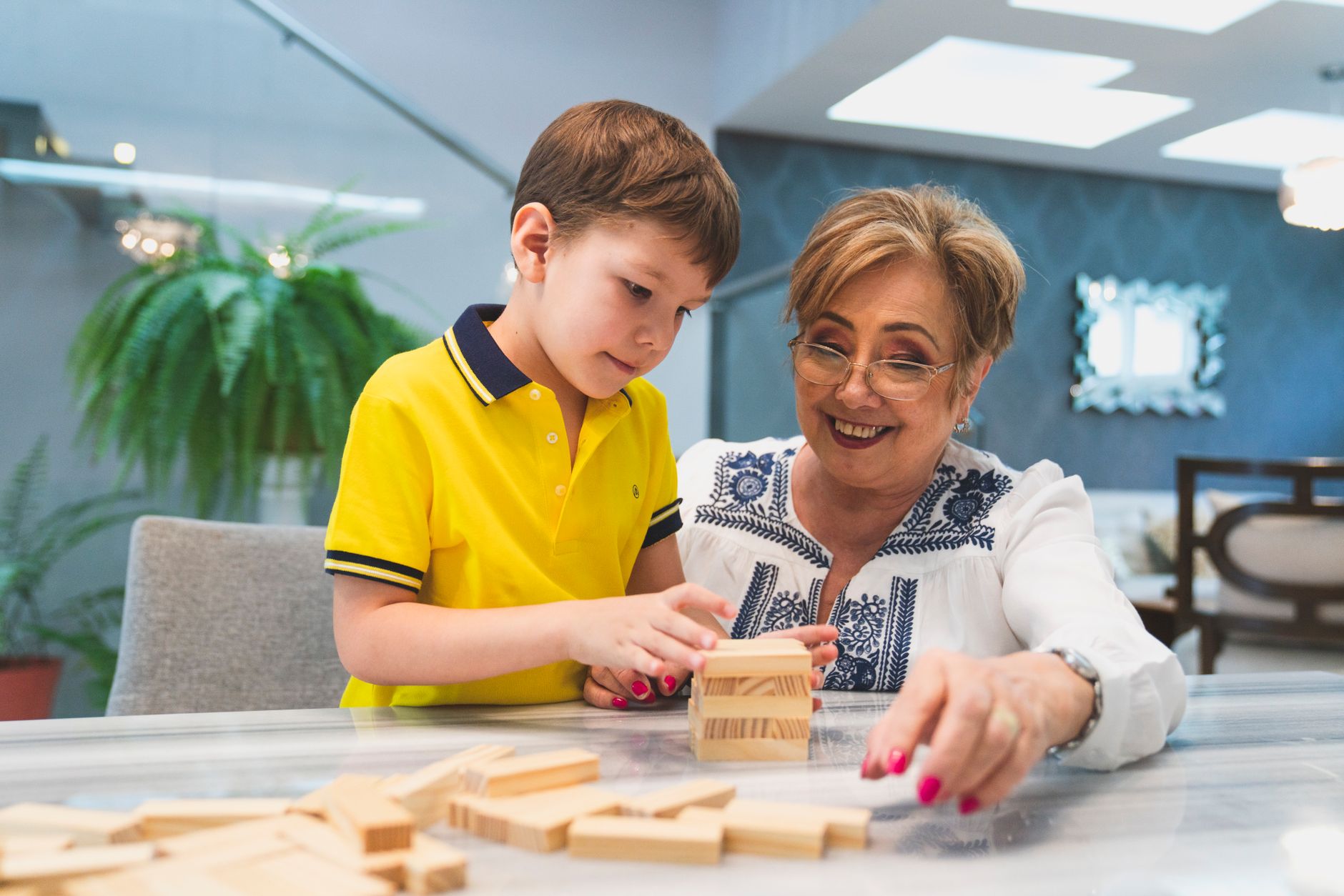 Grandmother and grandson playing with wooden building blocks together